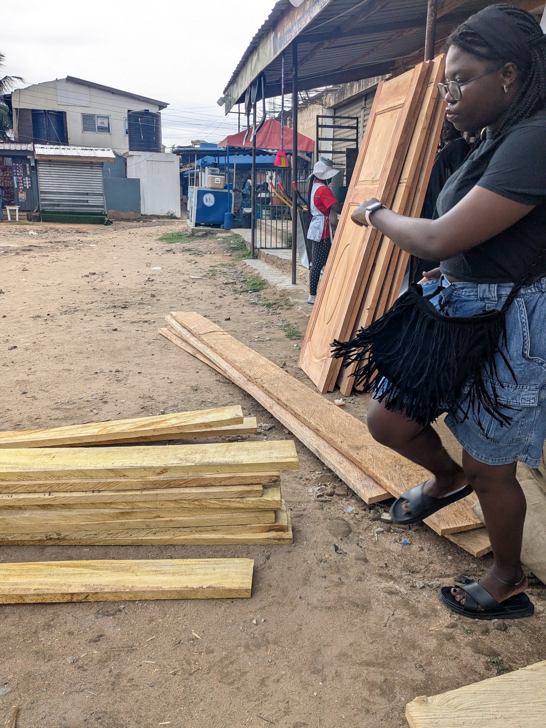 Team sourcing and pricing timber at a local building materials market near Agbogbloshie